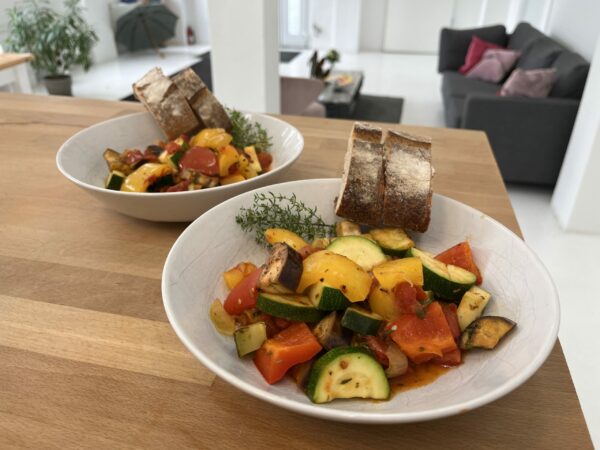 Rezept ratatouille - fertiges Ratatouille auf einem Teller mit Brot.