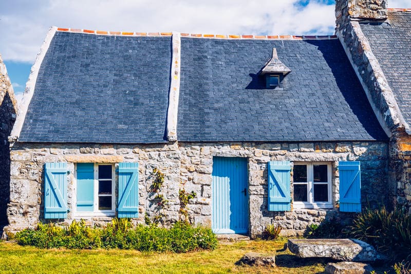 normandie frankreich traditionelles Steinhaus mit blauen Türen und Fenstern