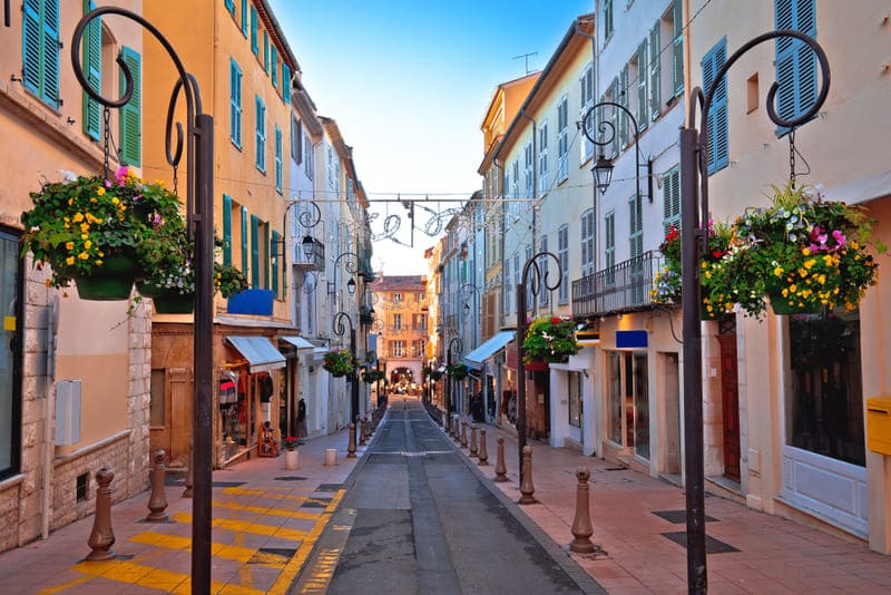 Wandern Provence durch die charmante Altstadt von Antibes mit bunten Häusern und blumengeschmückten Straßenlaternen