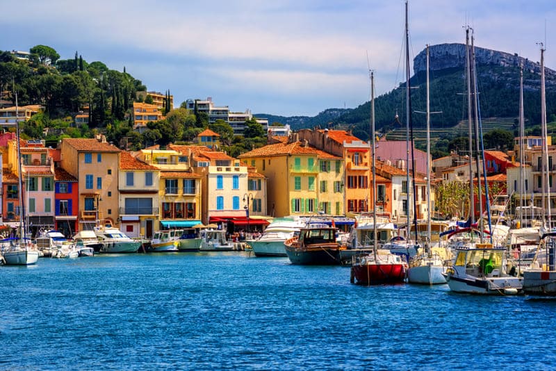 Wandern Provence entlang des farbenfrohen Hafens von Cassis mit Booten und bunten Häusern