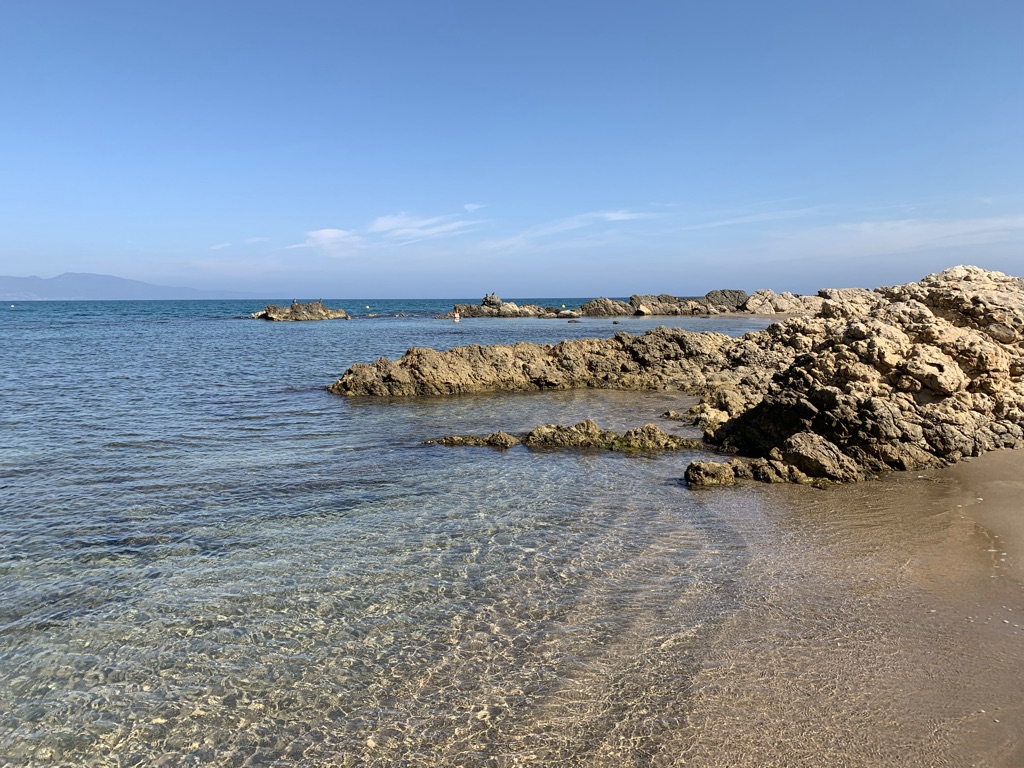 Strand mit Felsen und klarem Wasser an der Costa Brava bei L’Escala