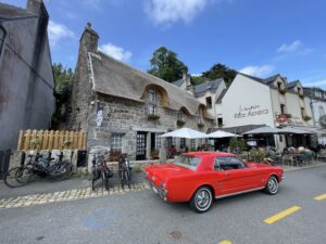 Mit Kommissar Dupin durch die Bretagne – Straßenszene mit traditionellem Steinhaus und Café in Pont-Aven