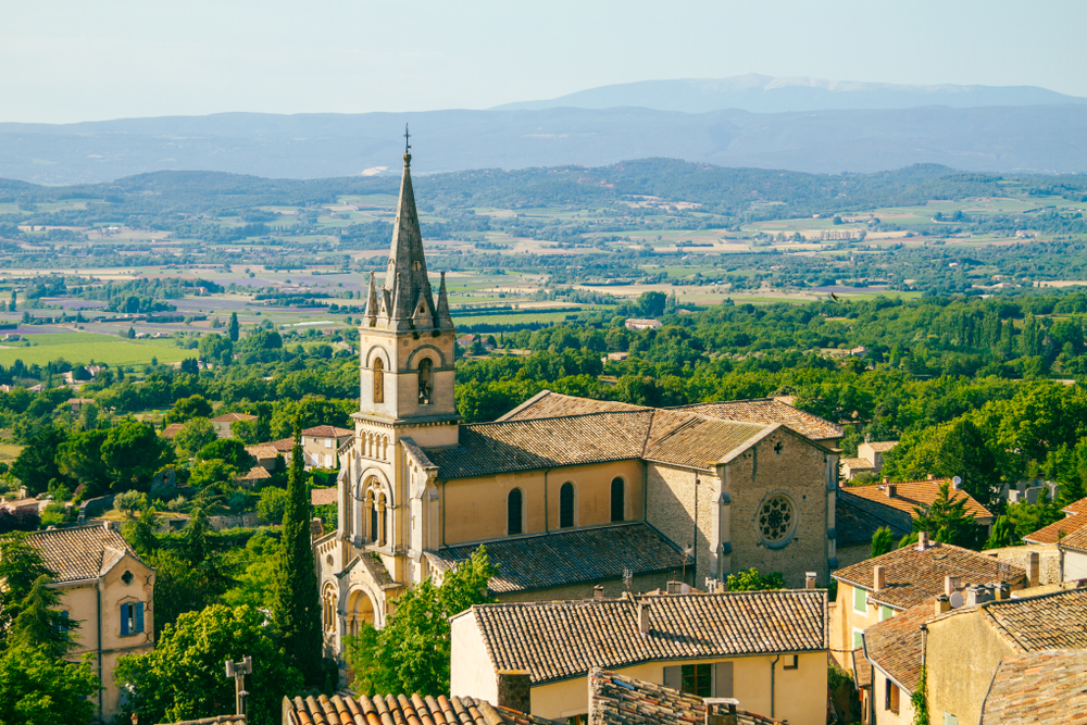 Ockerfarbene Kirche in Bonnieux im Luberon mit Blick in die Landschaft