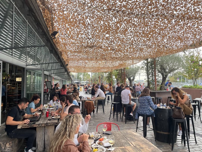 Gäste an langen Tischen in den Halles de Bacalan in Bordeaux