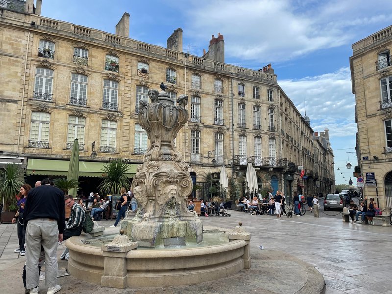 Brunnen auf der Place du Parlement in Bordeaux mit Cafés und Sandsteinfassaden