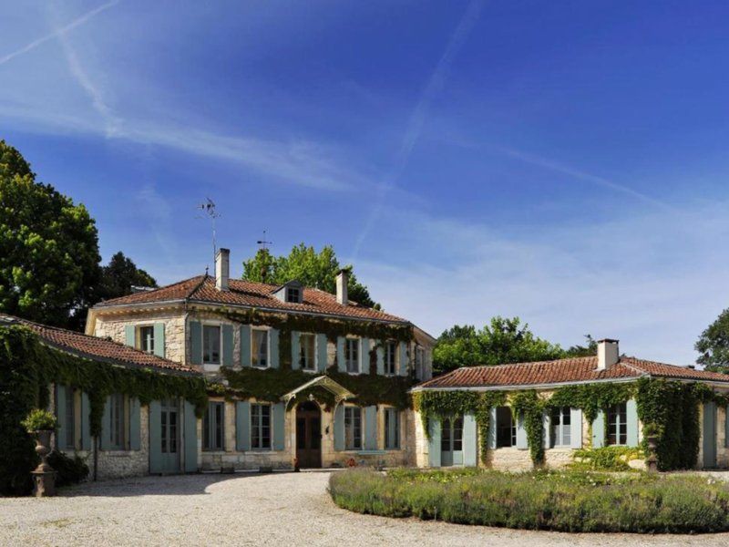 Außenansicht eines Château im Médoc mit Natursteinfassade und hellblauen Fensterläden