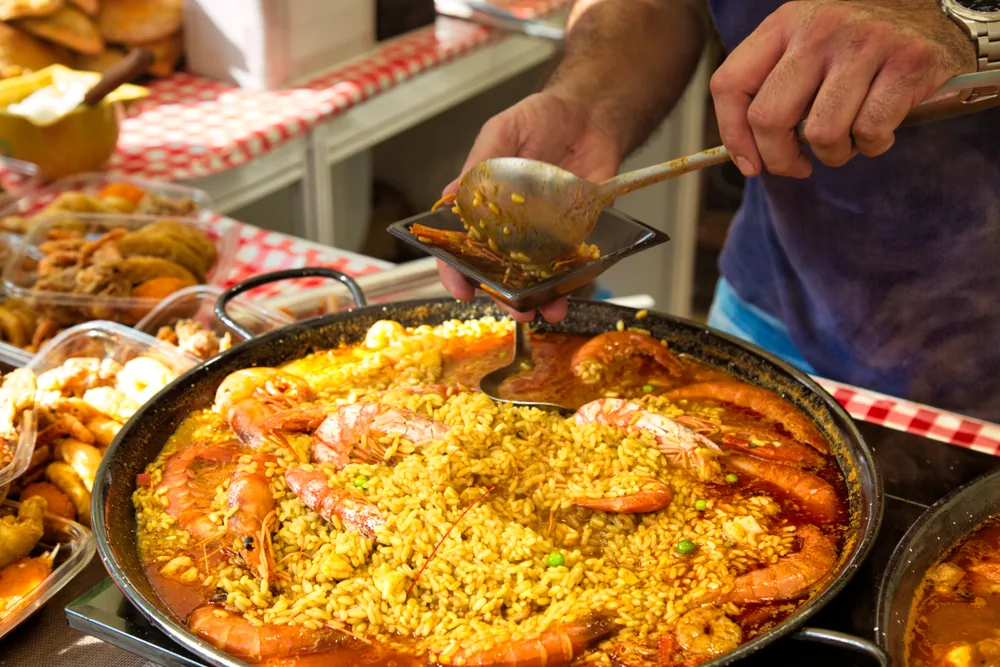 Große Pfanne mit Paella und Garnelen wird auf einem Markt in Katalonien serviert