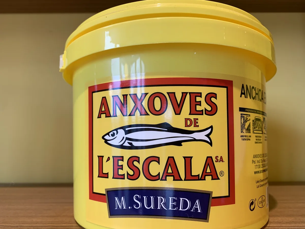 Gelber Eimer mit der Aufschrift Anxoves de l'Escala, traditionellen katalanischen Sardellen