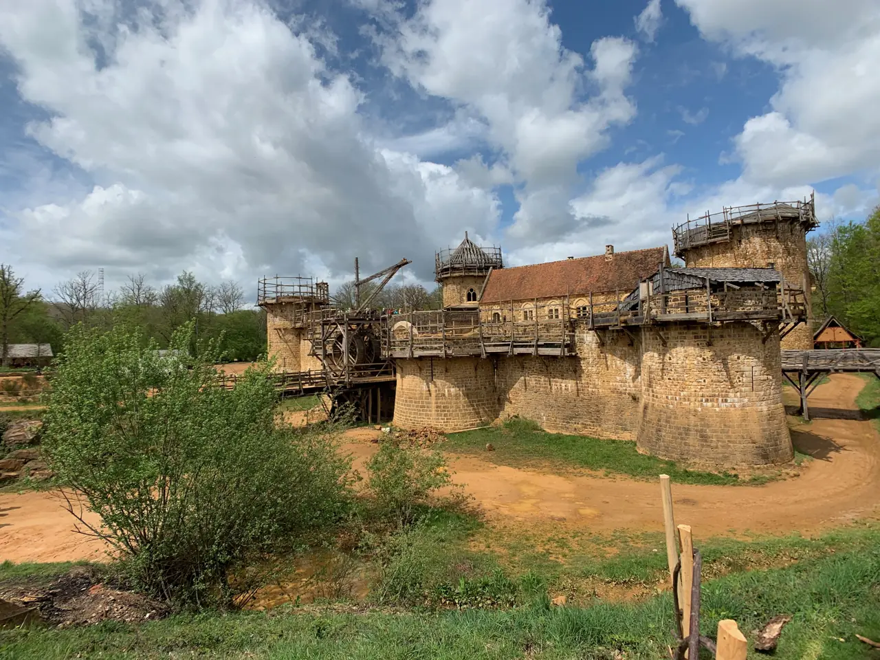 Die Burgbaustelle Guédelon mit Rundtürmen, Holzgerüst und Kran